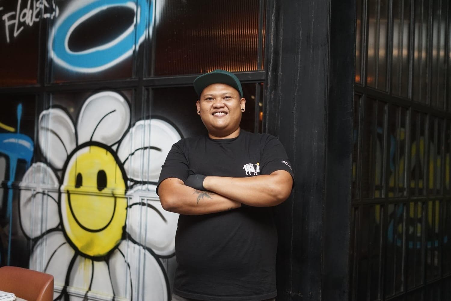 Raka Ambarawan, head of beverages for the Locavore Group, standing in front of a mural