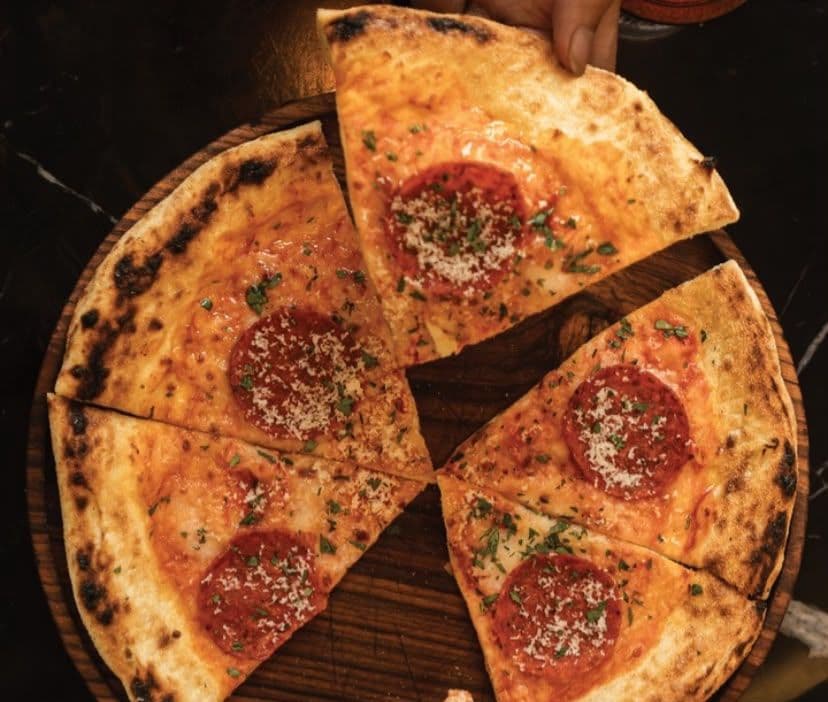 Diners sharing pizza at a restaurant in Canggu, Bali