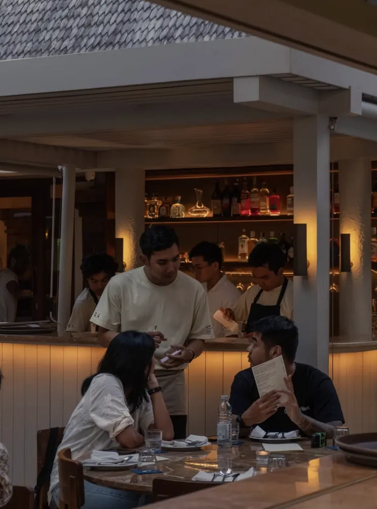 Server taking an order at the bar during evening service